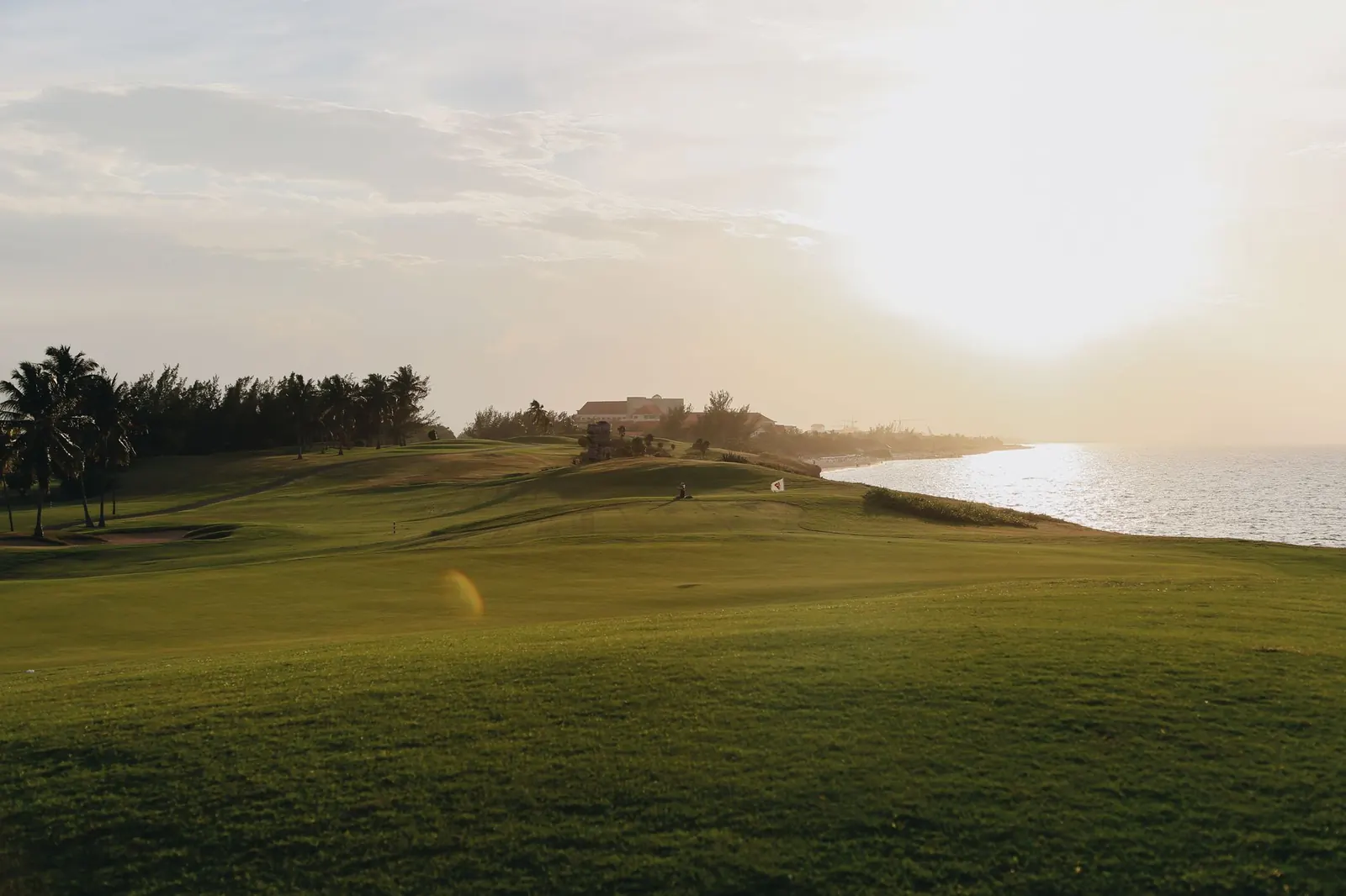 Bright sun over a golf course by the sea